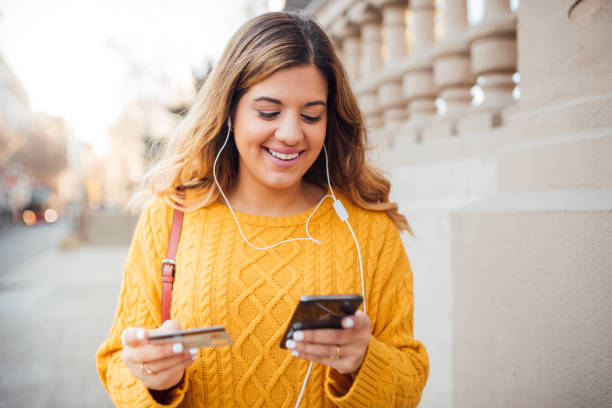 Joyful girl with headphones in her ears shopping online